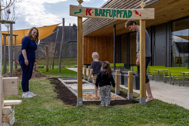 Kinder betreten Barfußpfad